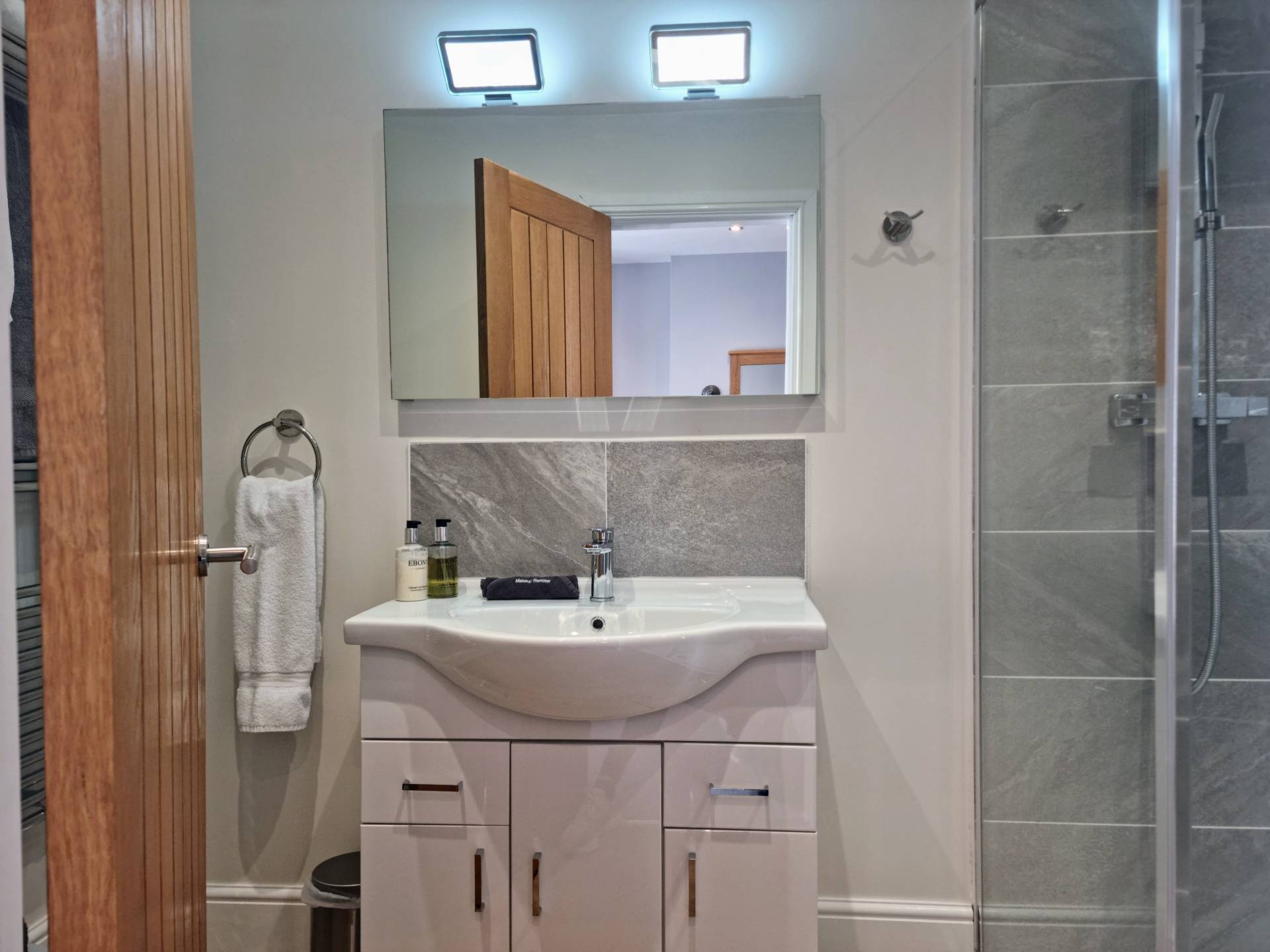Contemporary vanity unit with LED mirror, shaver charging point and heated demister pad in Suite 103.