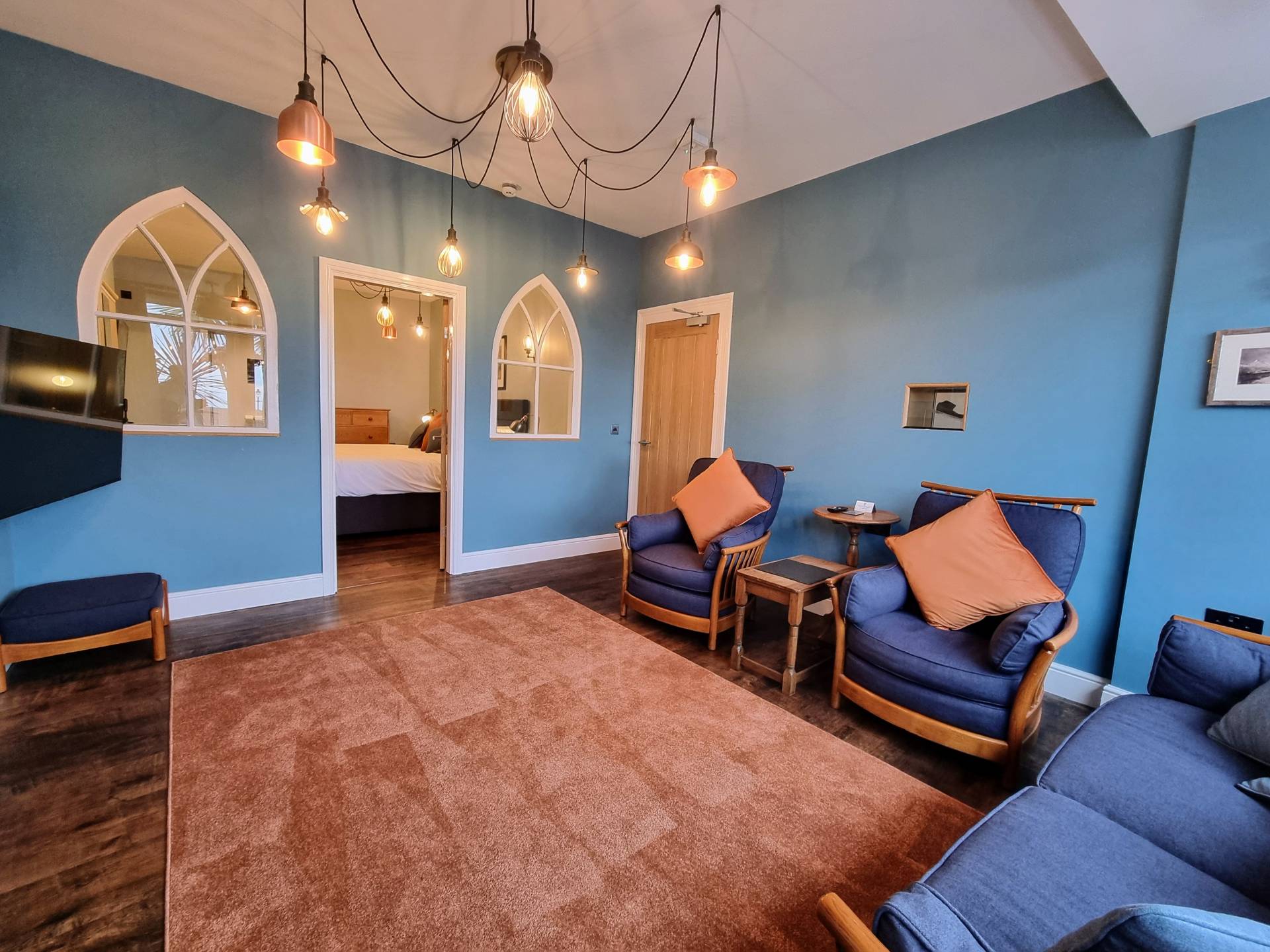 Lounge area in Suite 101 with views through the doorway and decorative arch windows into the bedroom.