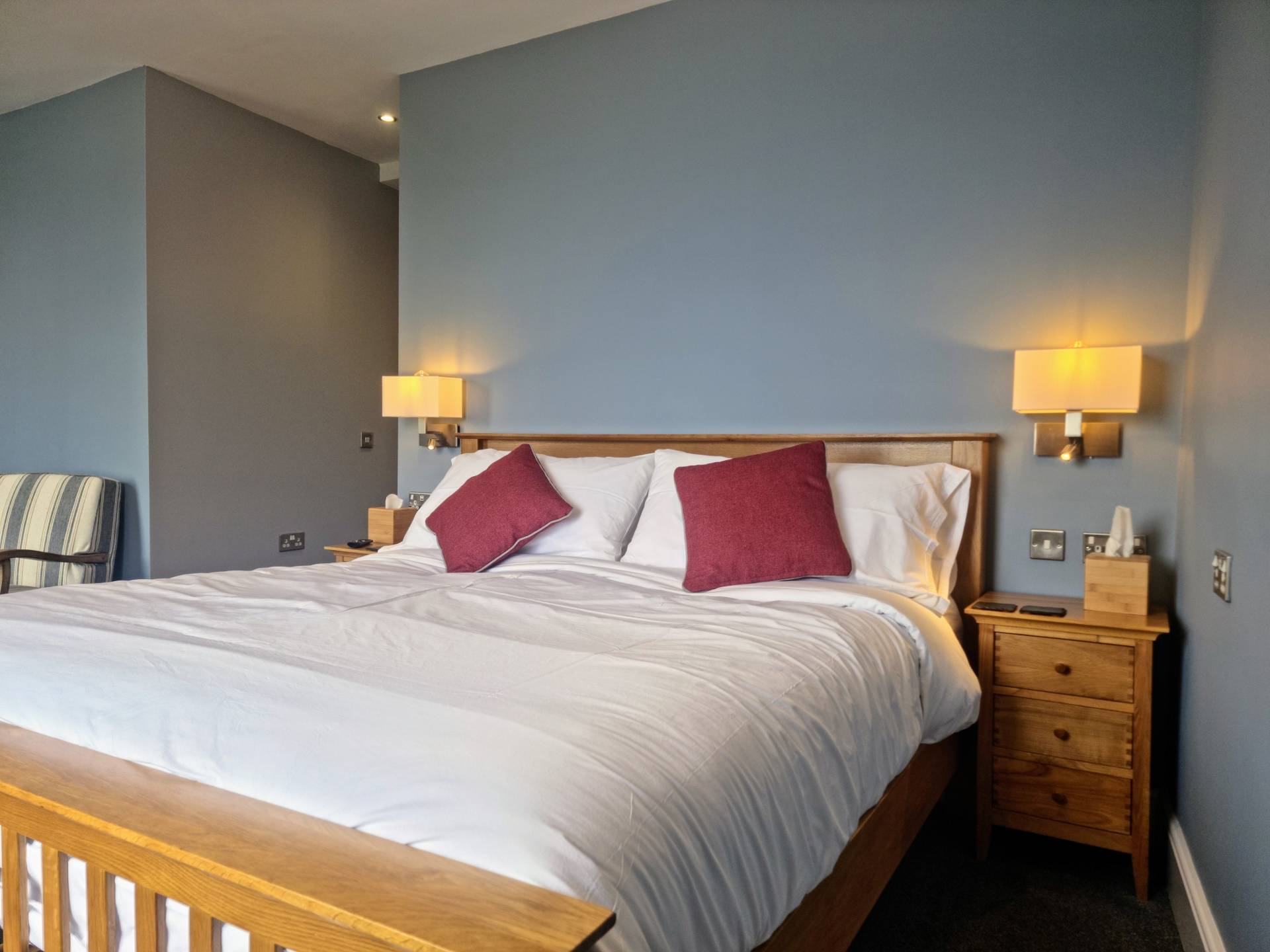 Luxurious super king bed with bedside lamps and USB charging sockets in Suite 103 at Min y Don Llandudno.
