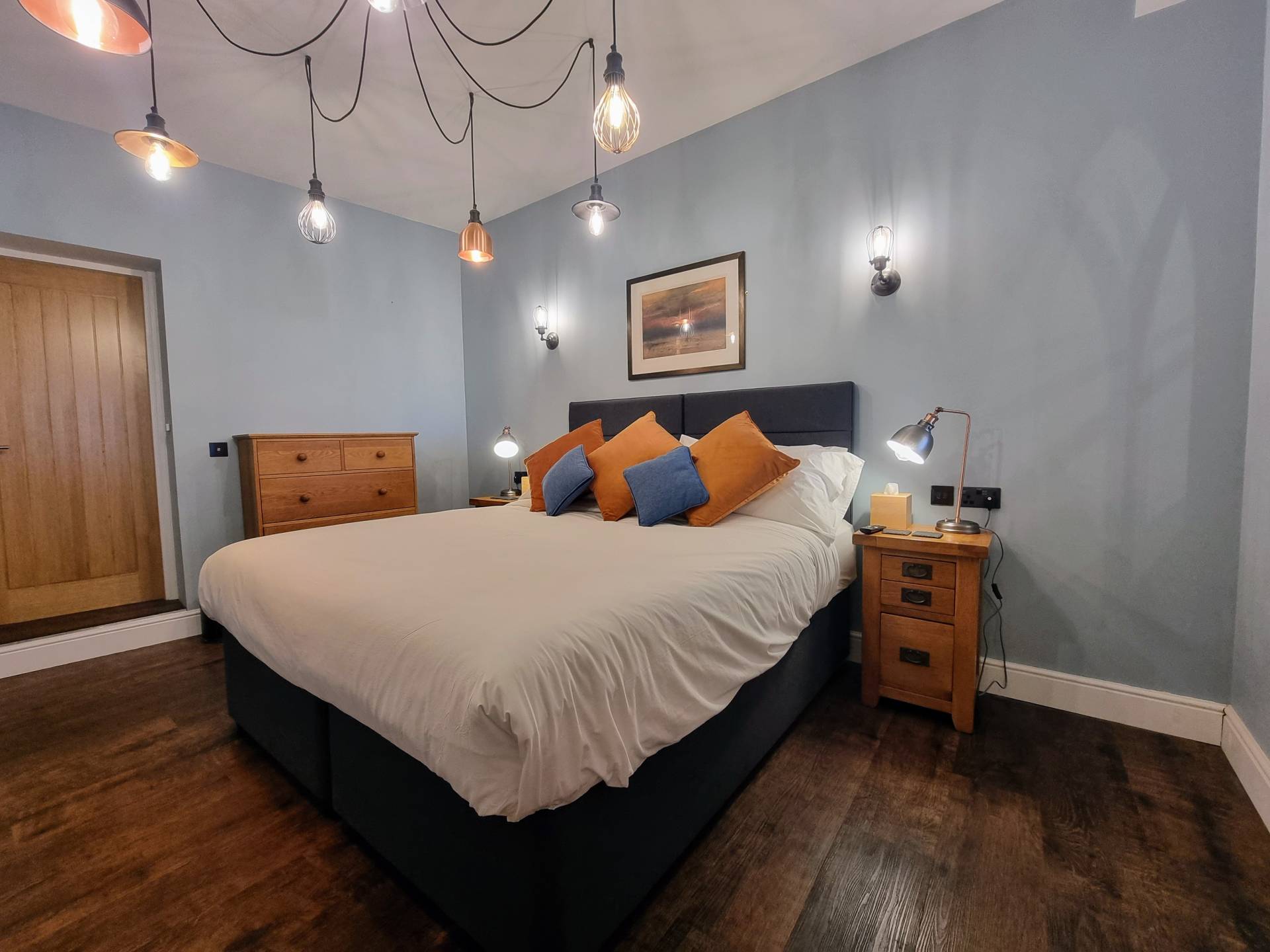 Super king bed with bedside lamps and USB charging points in Suite 101 at Min y Don Llandudno.