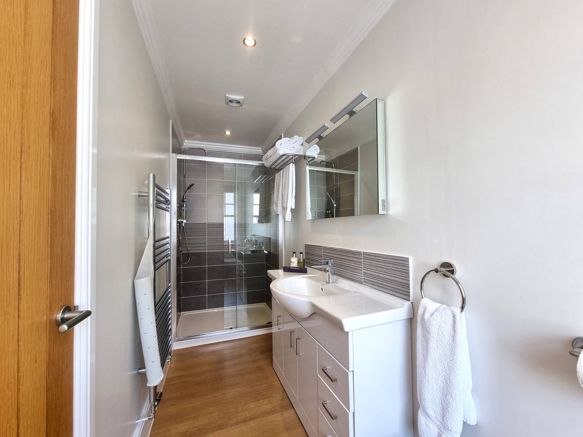 Luxury en-suite shower room in Room 301 at Min y Don Llandudno with shower, vanity, heated mirror, heated towel rails, and complimentary towels.