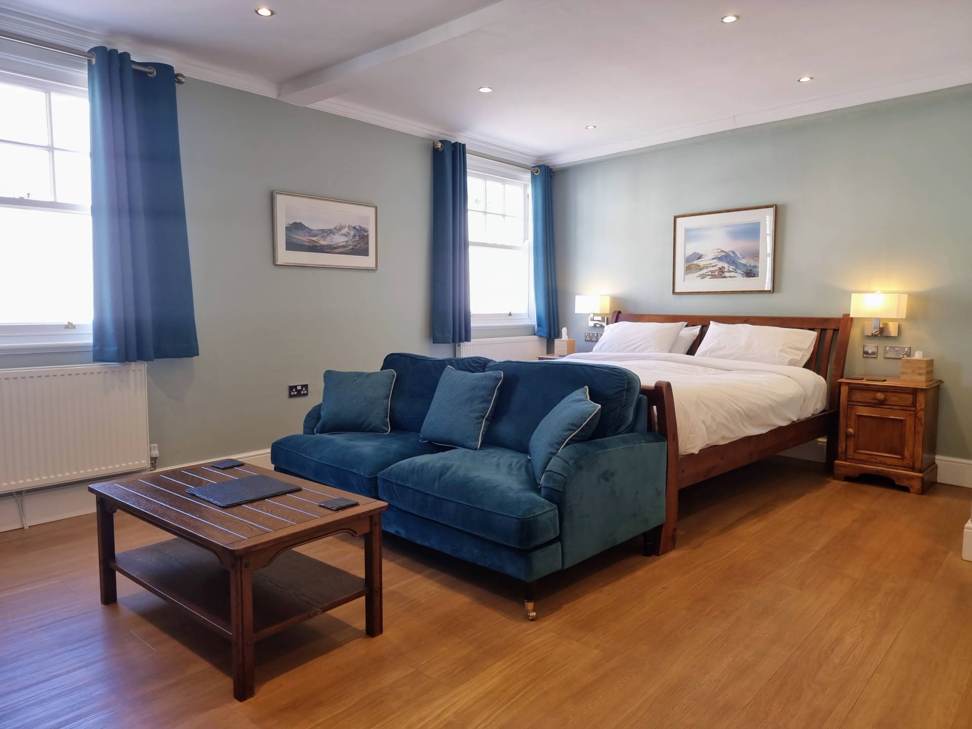 Suite 203 at Min y Don Llandudno showing superking bed and sofa from a different angle, with bedside lamps, reading lights, and USB sockets.