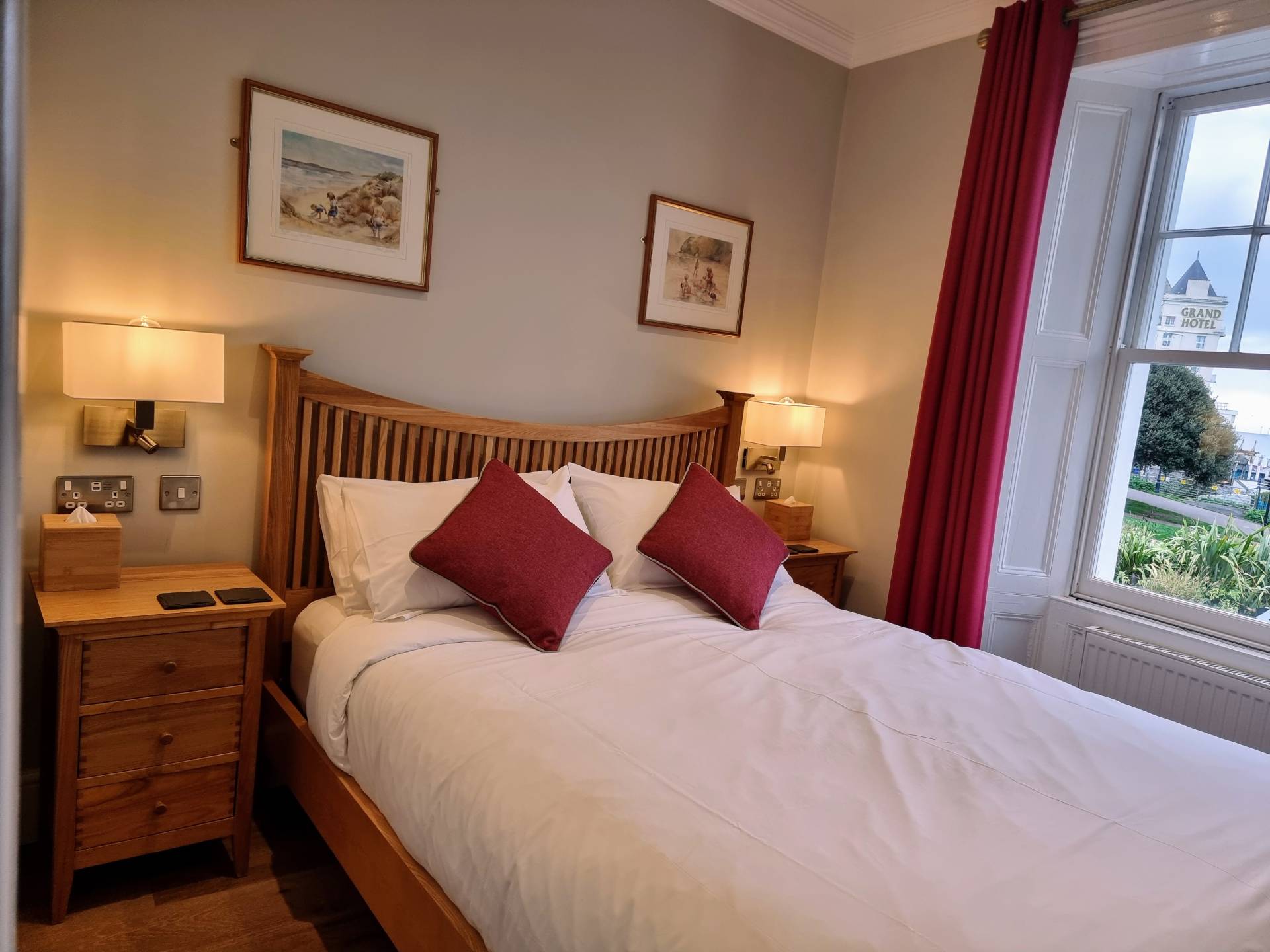 First Floor Sea View Room 101 at Min y Don Llandudno with king size bed, bedside cabinets, reading lights, USB sockets, and window view of Little Orme